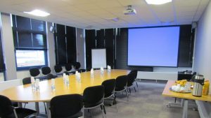 Salle de réunion avec table ovale et rétroprojecteur