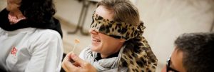Une femme les yeux bandés qui goûte un aliment